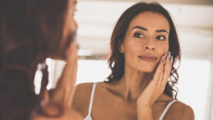 Person looking at skin in the mirror