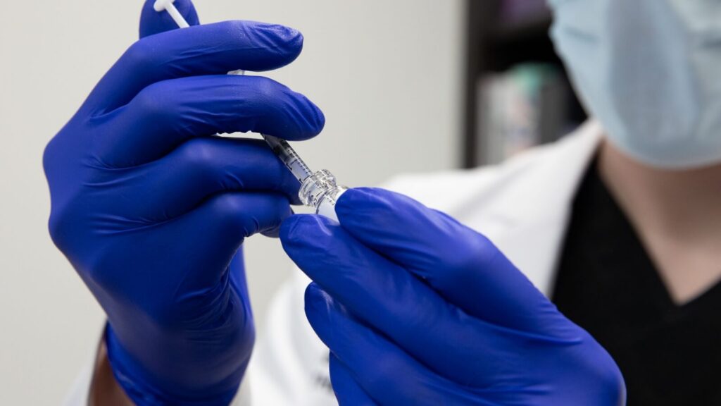 person holding a Botox needle