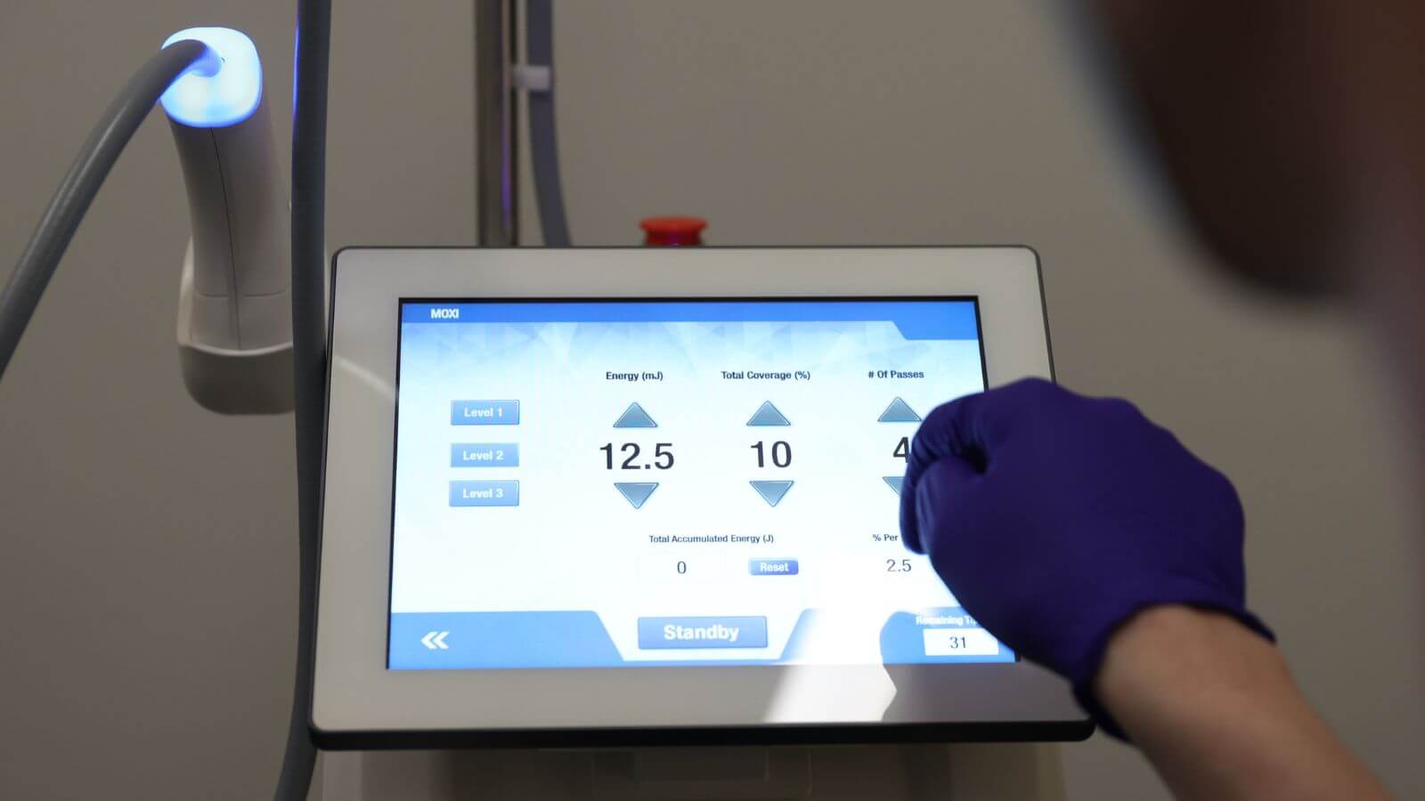 Aesthetician changing the moxi laser settings
