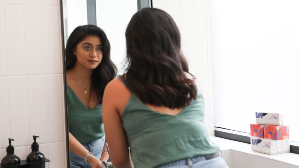 Girl looking at her facial features in the mirror