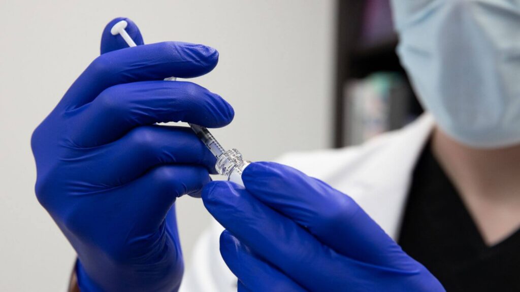 doctor filling syringe with liquid
